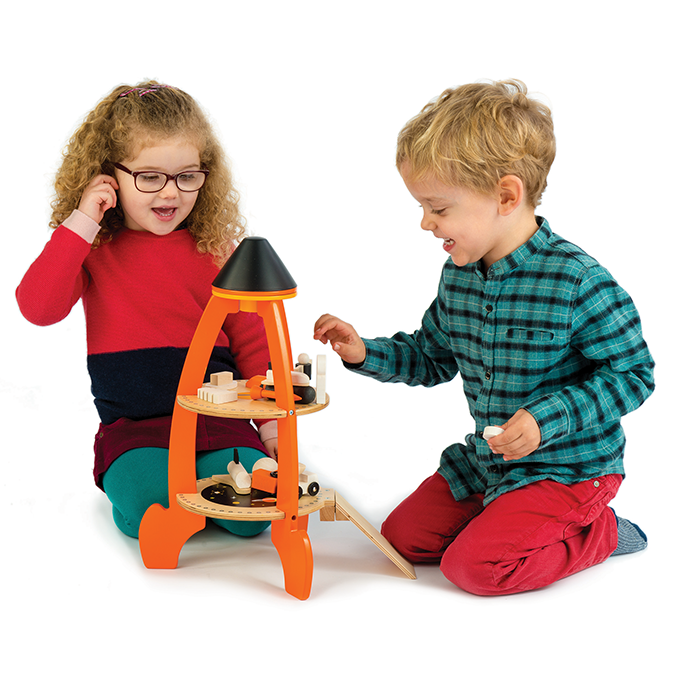 Two children playing with a toy rocket set on a white background